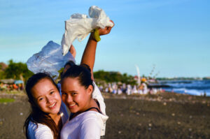 Mel+Bel holding plastic bags at beach Photo credit: Bye Bye Plastic Bags